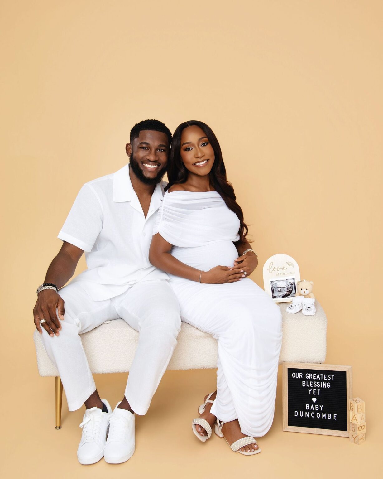 Expecting couple on a studio bench