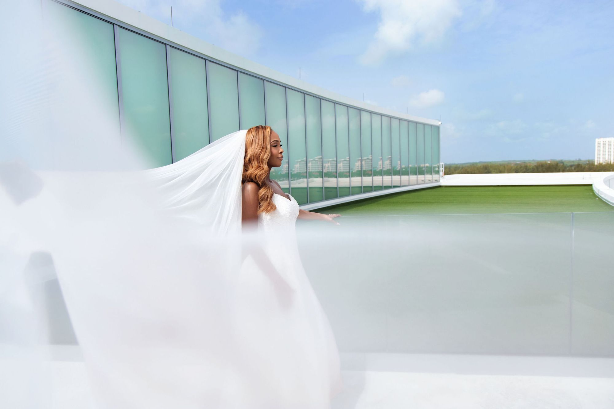 Bride on a rooftop with her veil in the wind