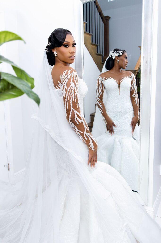 Bride in a beaded gown beside a mirror